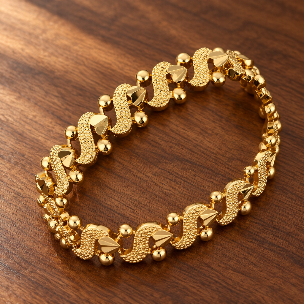 Gold-tone decorative bracelet with textured links on a wooden table