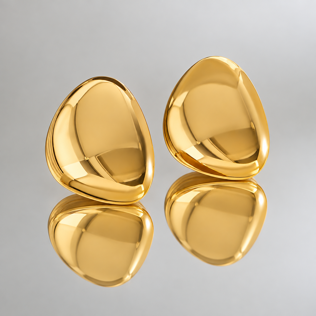 Pair of Carrie gold-tone rounded triangular earrings reflected in a mirror