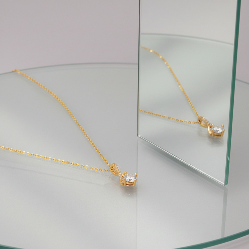 Gold zirconia pendant necklace on glass with mirror reflection