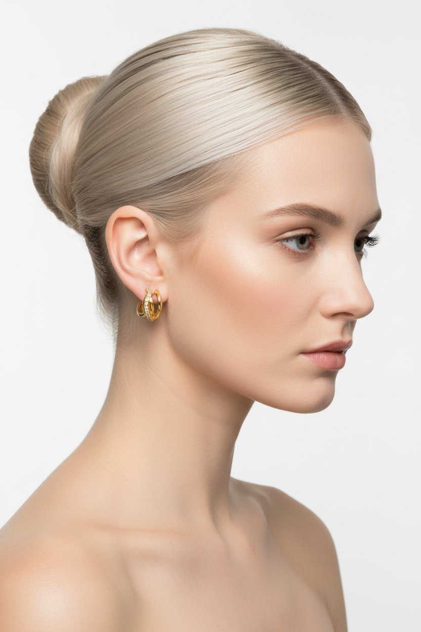 Blonde model with high ballerina bun wearing gold U-shape wave ear cuff with zirconia stones, 3/4 right profile bare shoulders