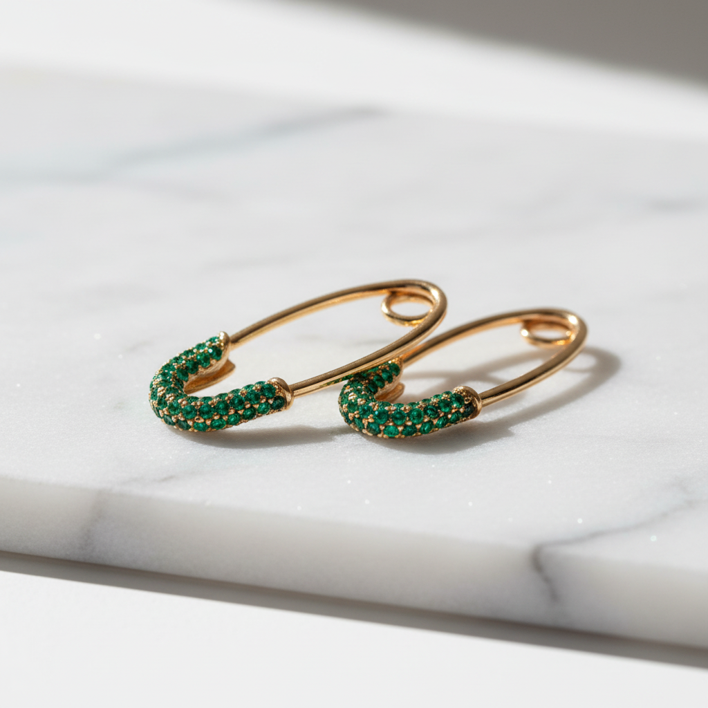 Gold crystal hook earrings with green zircon on white marble
