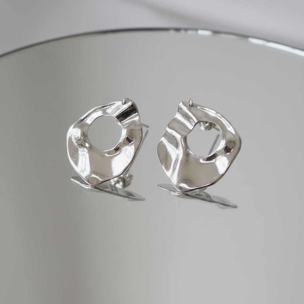Silver irregular waterdrop stud earrings on mirror surface