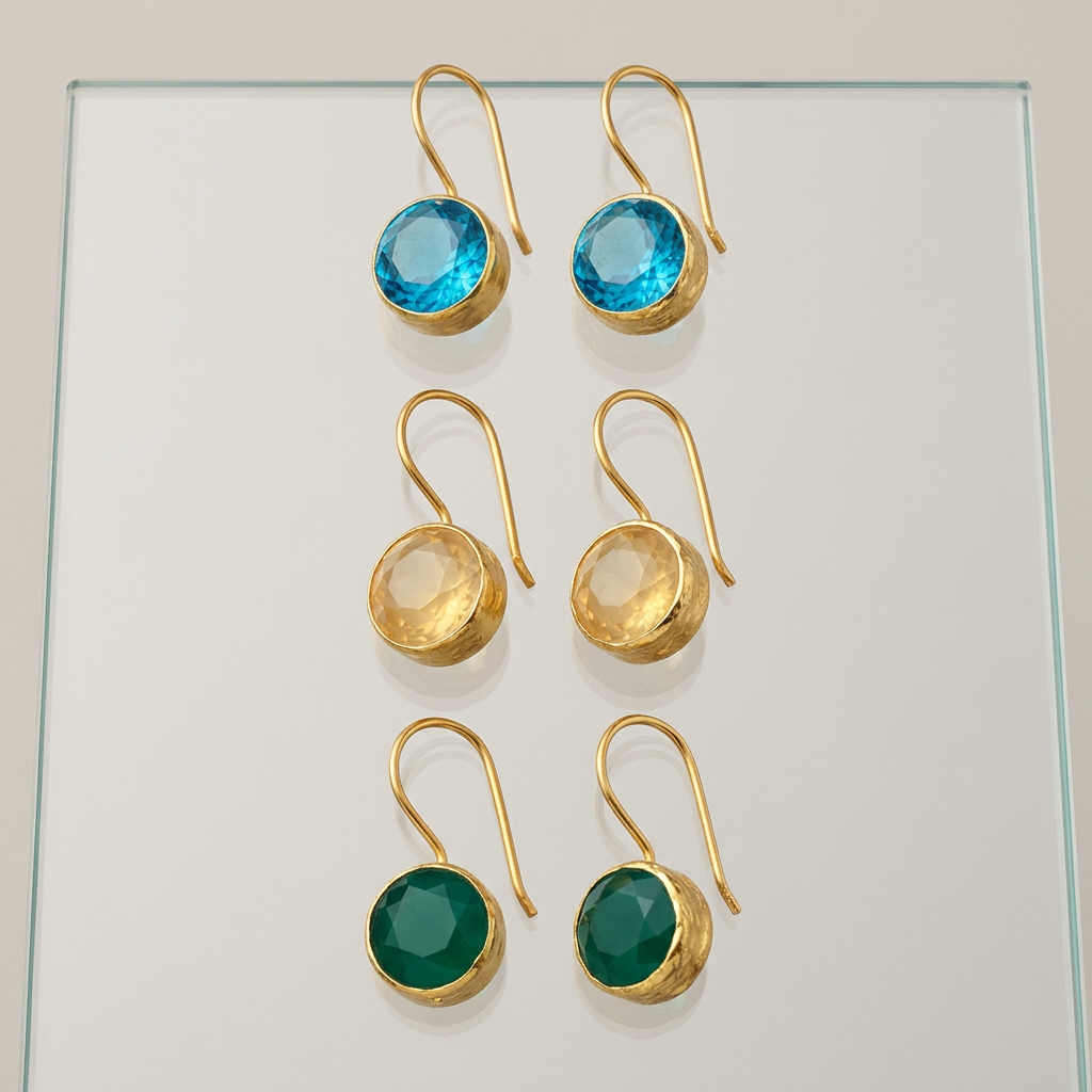 Minimalist faceted stone drop earrings on glass