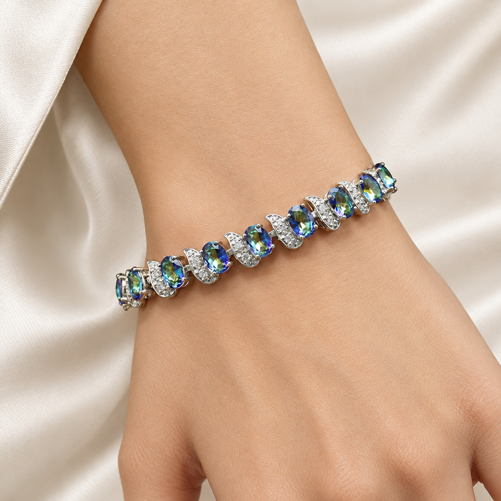 Colourful accent bracelet on a woman's wrist beside a cream silk sleeve