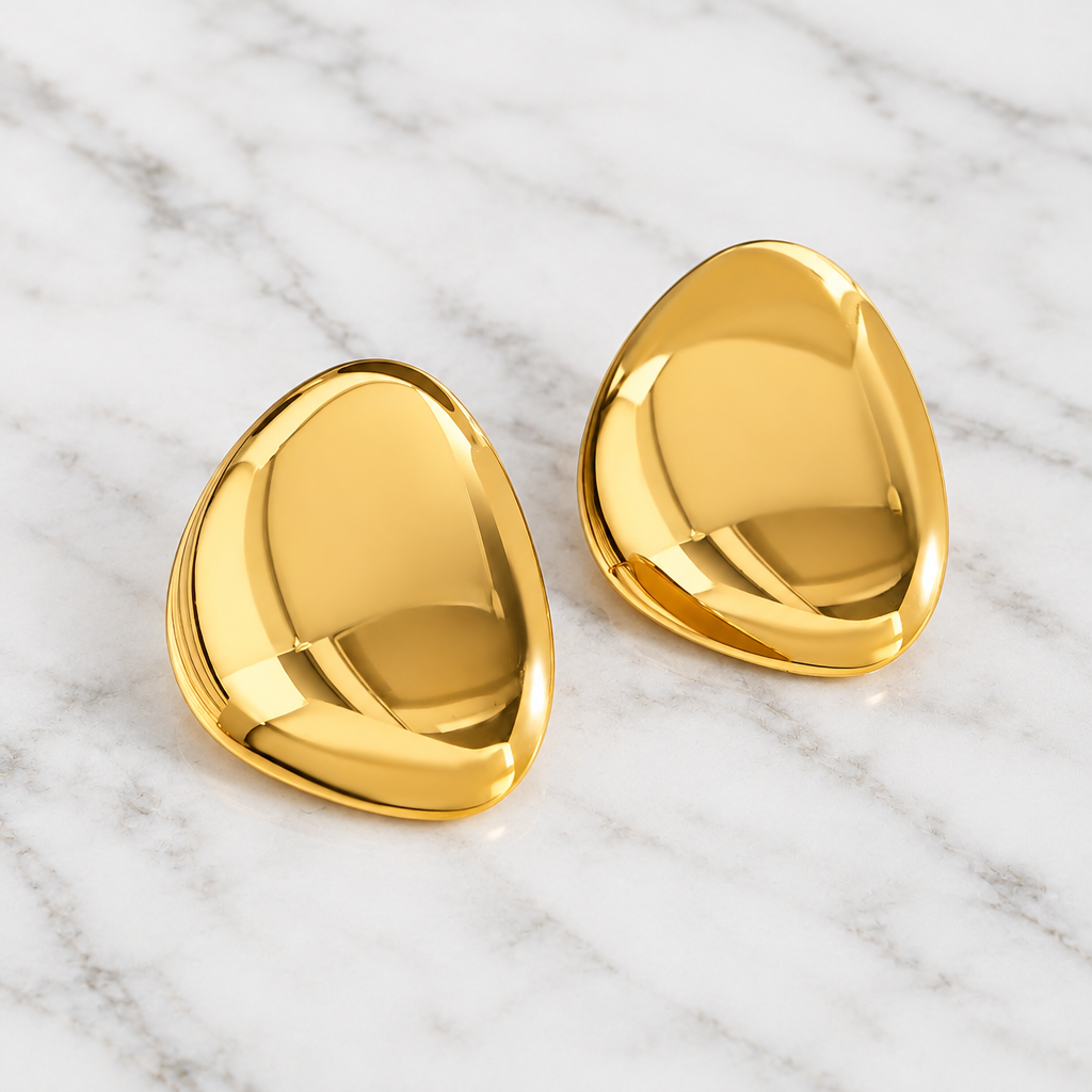 Pair of Carrie gold-tone rounded triangular earrings on white marble