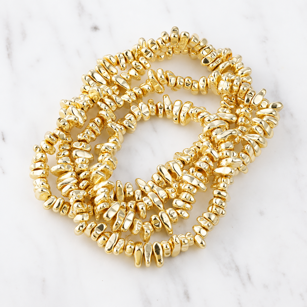 Gold-tone irregular bead bracelet on white marble