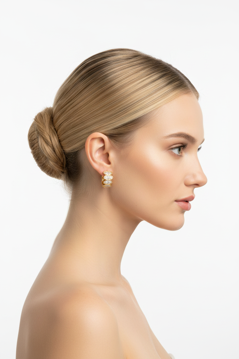 Blonde model in profile with ballerina bun wearing gold zircon huggie earrings