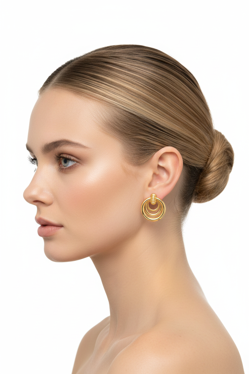 Blonde model left profile wearing small gold triple concentric ring earrings