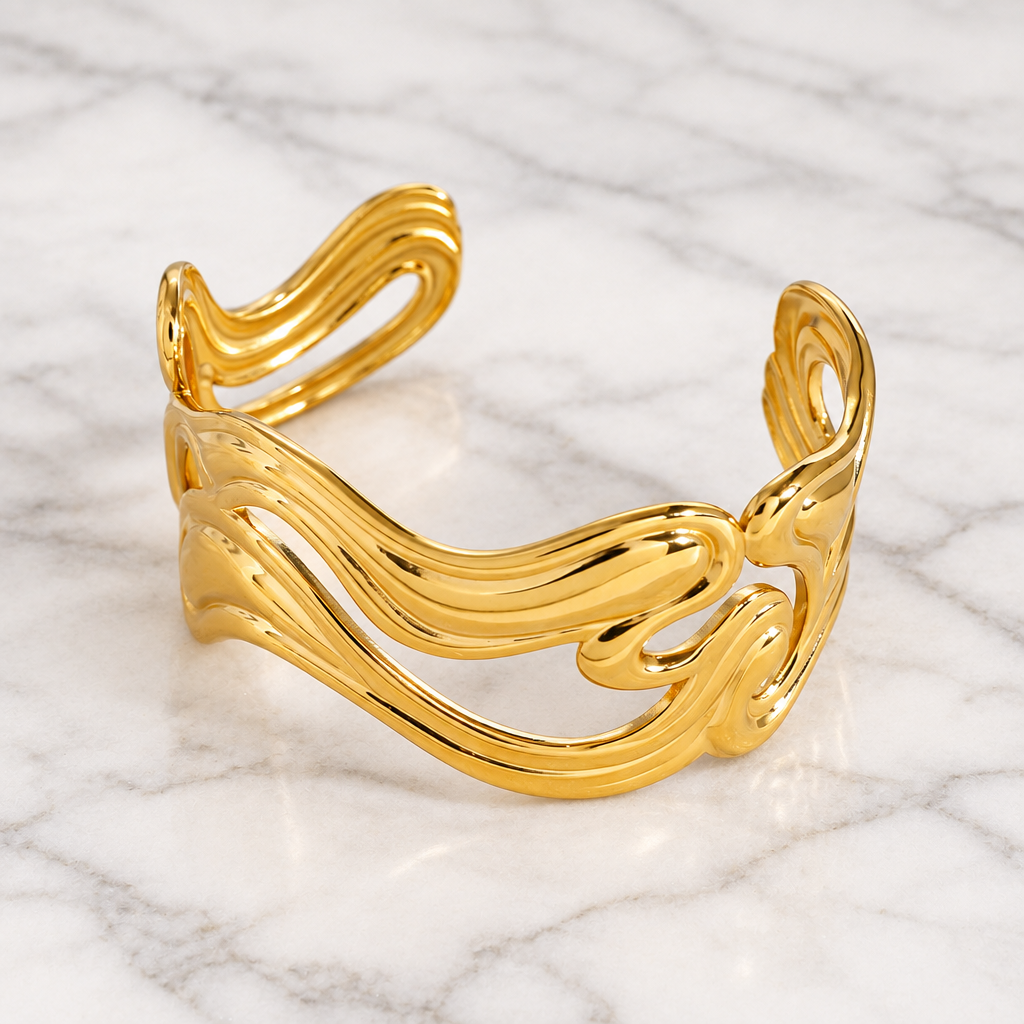Anissa gold-tone wavy open cuff bracelet on white marble