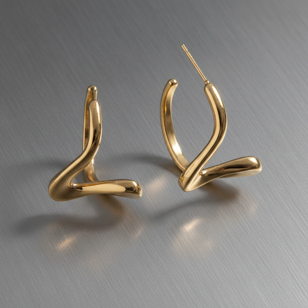 Gold Twisted Hoop Earrings on aluminum surface