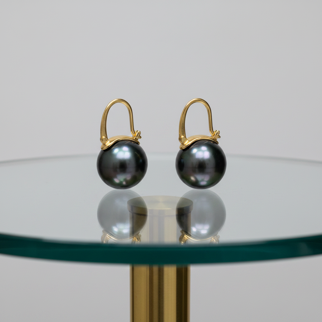 18K gold black Tahitian pearl ear clips on glass table