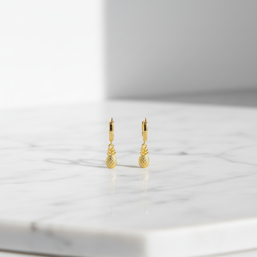 18K gold pineapple charm hoop earrings on white marble
