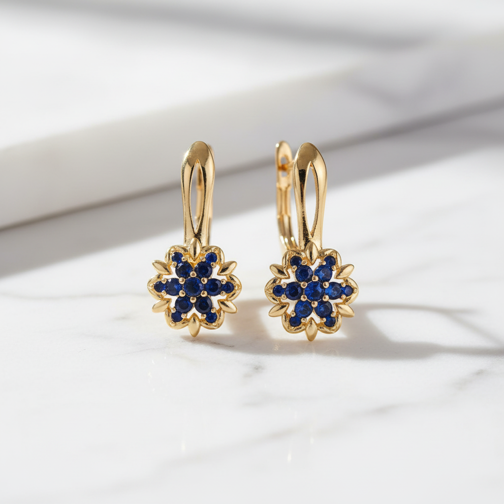 Gold sapphire sunflower drop earrings on white marble