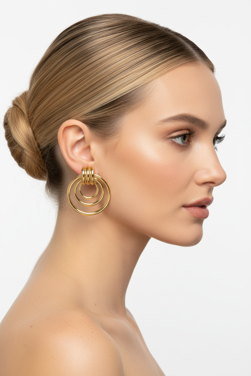 Blonde model right profile wearing small gold triple concentric ring earrings