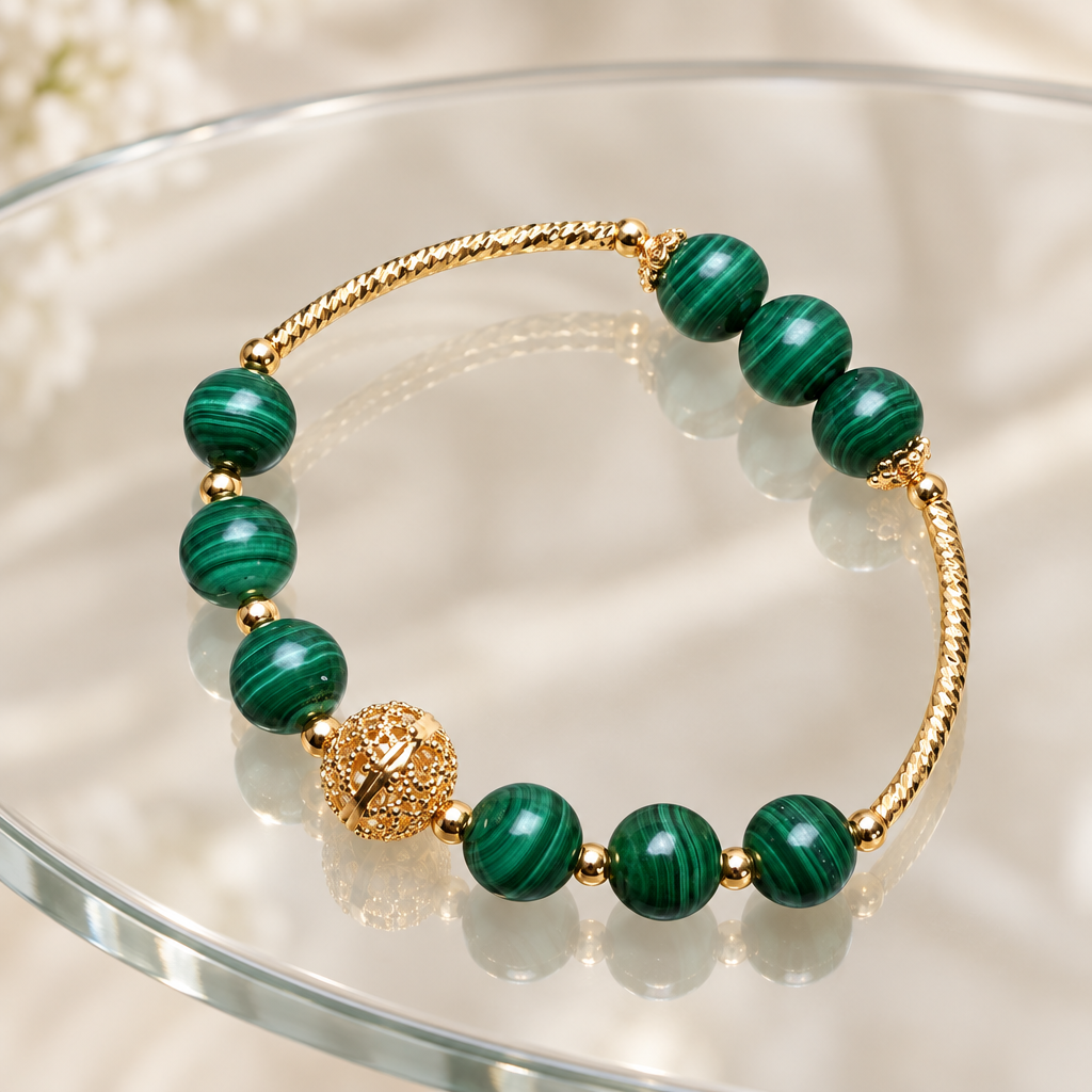 Malachite bead bracelet with gold-plated details on a glass table