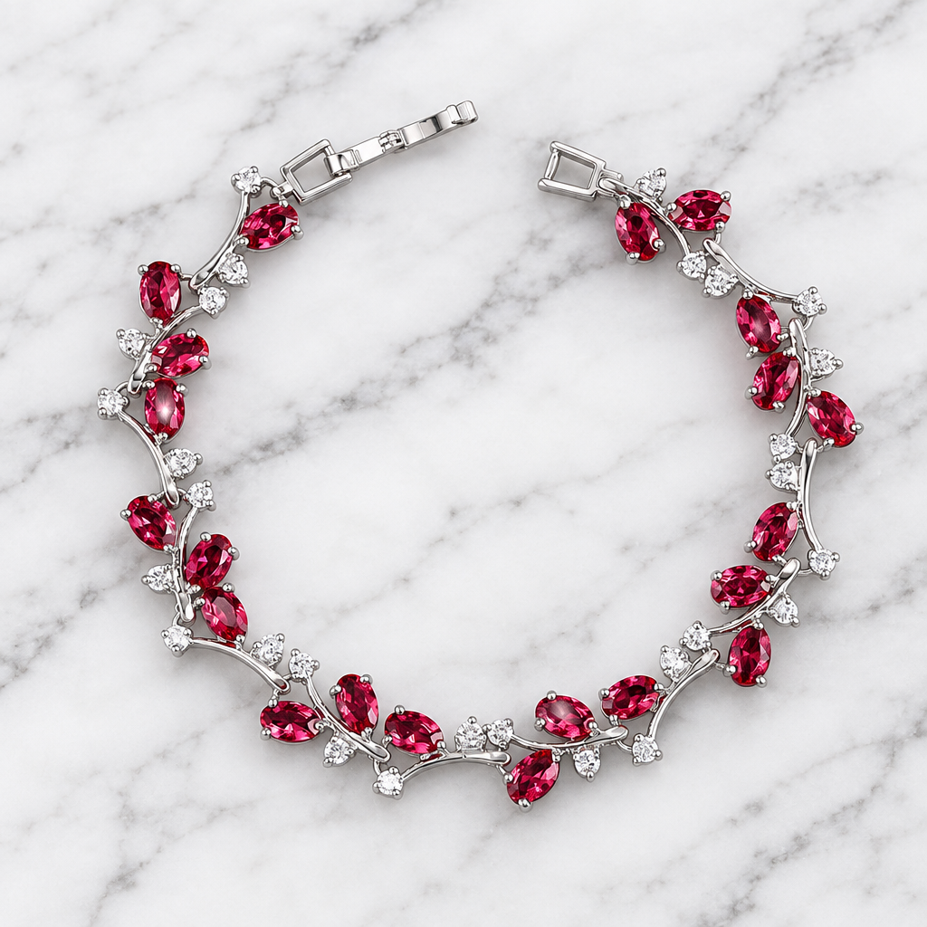 Silver-tone botanical bracelet with red marquise stones on white marble